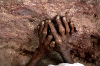 Hands touch a church wall in prayer, expressing deep spirituality, Lalibela, Amhara, Ethiopia