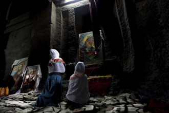 People praying in front of icons in Bete Medhane Alem, Lalibela, Amhara, Ethiopia