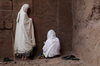 Women in white scarves praying on a church wall during Easter, Lalibela, Amhara, Ethiopia