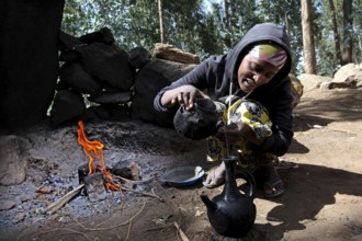 Woman prepares traditional coffee in the Lasta Mountains. The atmosphere is warm and inviting,