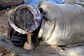 Hamer-Mann sleeps relaxed on traditional Berkota support, Turmi, null, Ethiopia