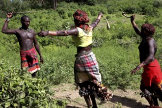 In the midst of lush nature, Hamer woman perform a whipping as part of a traditional initiation