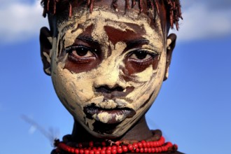 Young Hamer with artistic face painting against a clear sky, Turmi, Ethiopia