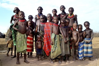 Young woman and children pose happily for a group photo in Omorate, Omorate, Ethiopia