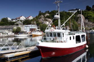 View from Kirkelandet marina on Gomalandet with fishing boat and houses in the background,