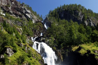 Impressive Låtefossen waterfall with steep rocks in the background and lush vegetation, zero