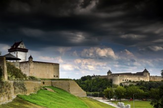 View of Hermann Fortress and Ivangorod in Narva with dramatic clouds in the sky, Narva, Estonia