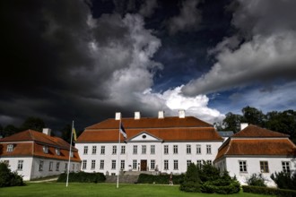 Historic manor house with red roofs under dramatic sky, Suuremäisa, Hiiumaa, Estonia