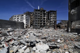 Abandoned ruins of Gunkanjima with crumbling buildings and debris under clear skies, Nagasaki,