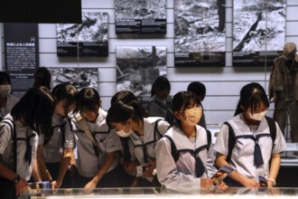 Group of students visiting the atomic bomb museum in Nagasaki, deeply immersed in the topic,