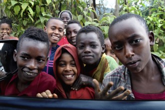 Group of kids smiling happily at the camera along the route from Yirga Alem to Yabello, Yirga Alem,