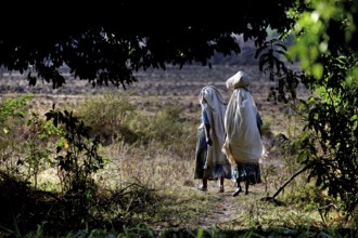 Two woman wearing traditional clothing in a natural setting, Tisissat, Ethiopia