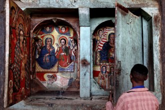 Person in front of icons in a decorated wooden structure, Tana Lake, Ura Kidhane Mihret, Ethiopia