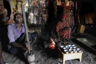 Women prepare traditional food at a fireplace in a hut, Yirga Alem, Ethiopia