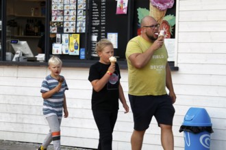 Family enjoying ice cream in front of an ice cream shop in Porvoo, Porvoo, Finland