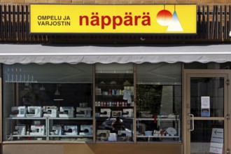 Shop front with yellow Näppärä sign and shop window of a textile shop, Rovaniemi, Finland