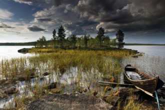 Lapland shows a picturesque lake landscape with a small boat on the shore under a dramatic cloud