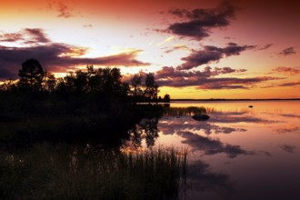 Sunset over a lake landscape in Lapland, the sky glows in intense colors, Lapland, Finland