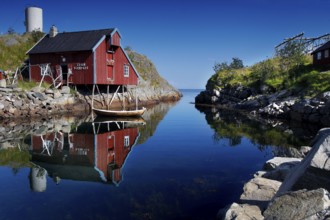 Red house reflected in calm water in Å, Moskenesøy, Å, Moskenesøy, Norway