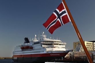Hurtigruten ship with Norwegian flag in Svolvær harbour, clear visibility and blue sky, Svolvær,