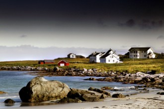 Small settlement with white houses on the beach, surrounded by rocks and sea, Ramberg, Flakstadøy,