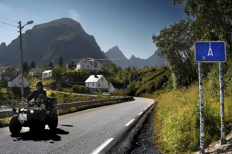 ATV on a road in Å, surrounded by the impressive mountain scenery of Lofoten, Å, Moskenesøy, Norway