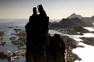 The distinctive rock pin Svolværgeita rises over an extensive coastal landscape, Svolvær, Nordland,