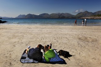 Relaxed beach atmosphere on Austvågøy with calm sea and sunbathing people, Lofoten, Nordland,