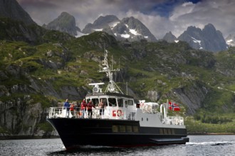 Tourists enjoy a boat trip in Trollfjord with mountain backdrop, Austvågøy, Raftsund, Norway