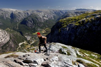 Hikers climbing Mount Kjerag with breathtaking mountain scenery in the background, Lysefjord,