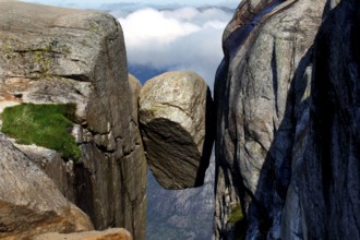 The Kjeragbolten is impressively enthroned between two majestic rock faces, Kjerag, Rogaland,
