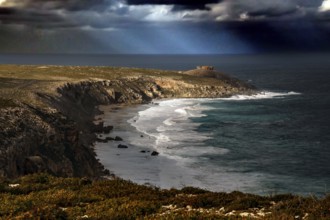 The dramatic coastline of Cape du Couedic with strong swell under dark skies, Kangaroo Island,