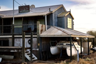 Rustic Lake Eyre Yacht Club building with moored boats in Marree, Marree, South Australia,