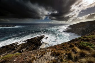 Stormy sea meets impressive coastal cliffs under impending clouds, zero
