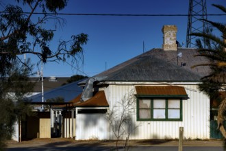 Single-family house in Marree with surrounding vegetation and blue sky, Marree, South Australia,