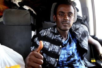 Young man in car in Berhaile showing thumbs up, smiling gesture, Berhaile, Ethiopia