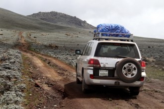 A land cruiser climbs a rocky road in the Sanetti Plateau, Bale Mountains, Oromia, Ethiopia
