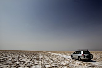 An off-road vehicle on a wide salt crust in the Dallol Desert, Dallol, Afar, Ethiopia
