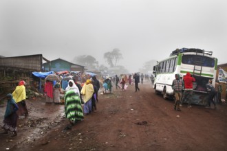 Different people and a bus on a foggy road in Rira, Rira, Bale Mountains, Ethiopia