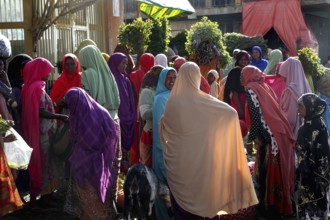 People wearing colorful robes at a busy market, Awaday, Ethiopia