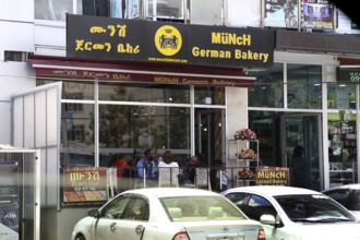 Modern German cafe in an urban setting in Addis Ababa, with cars in the foreground, Addis Ababa,