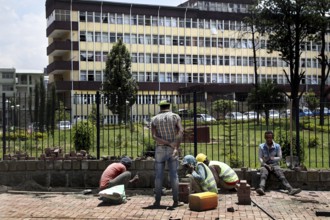 Workers maintaining sidewalks in front of a municipal building, Addis Ababa, Ethiopia