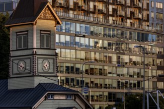 Wooden church in front of a modern glass façade in the Rotermann quarter, reflective architecture