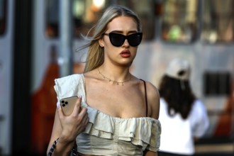 Woman wearing elegant dress wearing sunglasses strolling through a street in Tallinn, Tallinn,