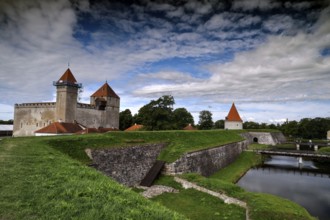 Historic Episcopal Castle of Arensburg with distinctive towers and moat in the foreground,