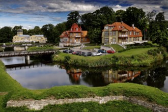 Historic buildings and hotel Ekesparre on the moat with picturesque reflection in the water,