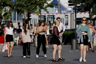 People stroll through the sunny old town, dressed in casual summer clothes, Tallinn, Harju, Estonia