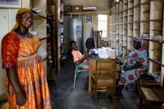 Three woman in a pharmacy scene surrounded by shelves full of medicines, bouké, region, Côte