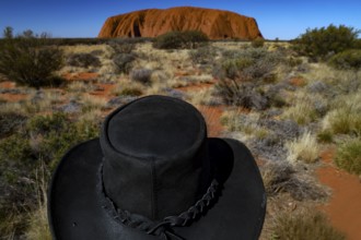 Black hat against the monumental Ayers Rock backdrop in the Australian Outback, Uluru, Northern