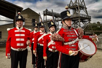 Soldiers wearing historic red uniforms in front of a gold mine in Sovereign Hill, Ballarat,